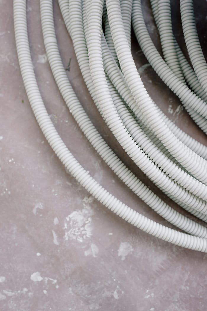From above of plastic wires on dirty floor during renovation in room at home